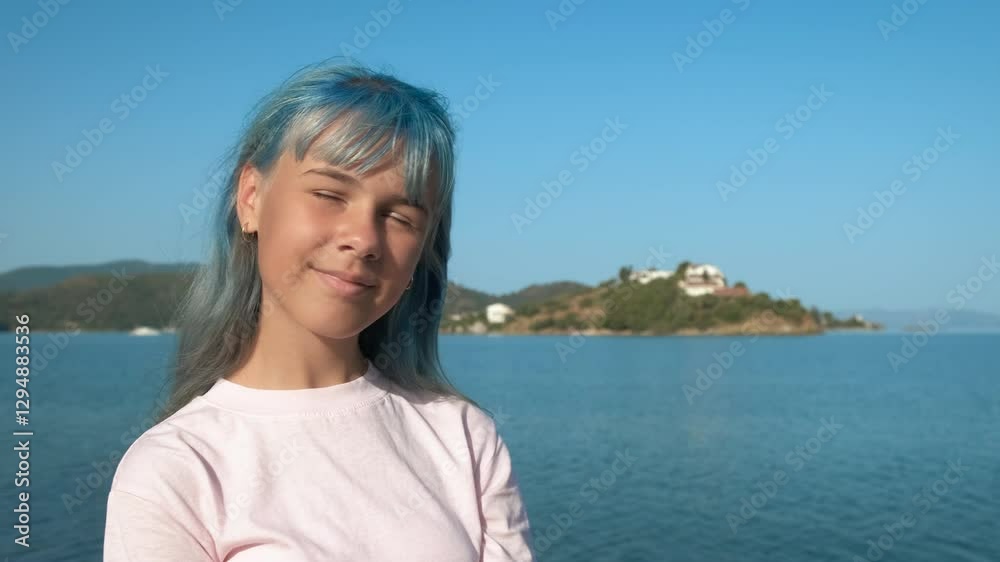 Portrait of a girl with blue hair. Pretty girl with blue hair on the background of a blue seascape. Portrait of a girl with blue hair. Pretty girl with blue hair on the background of a blue seascape.