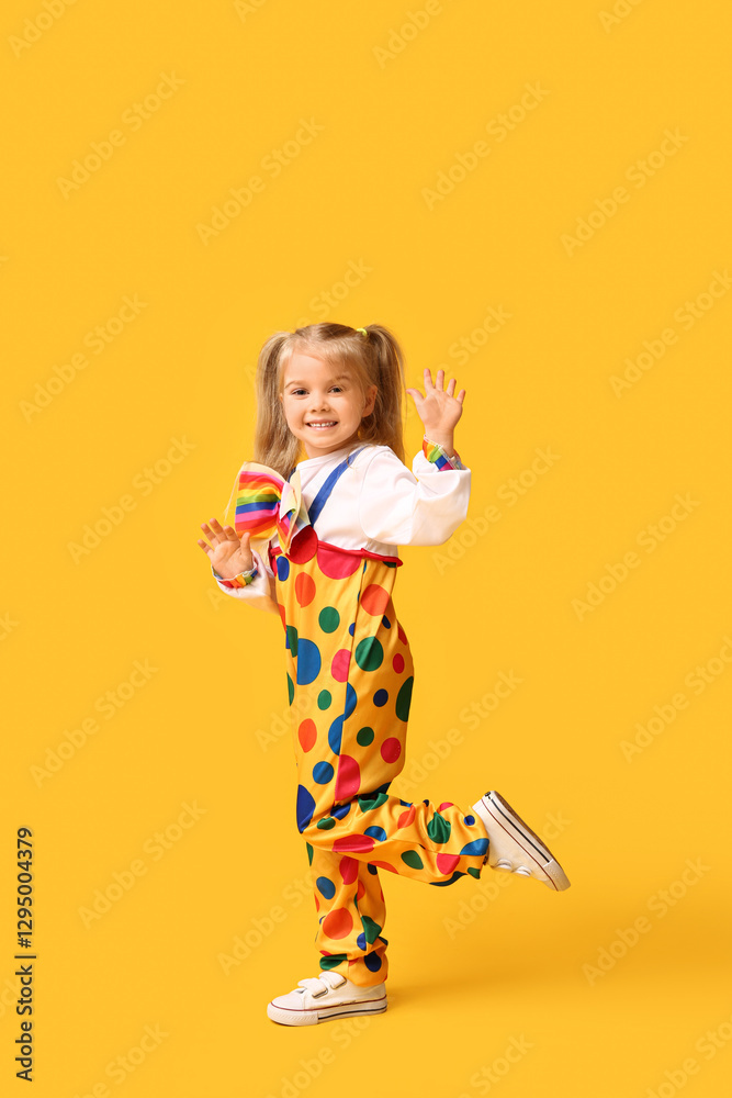 Smiling little girl in clown costume on yellow background Smiling little girl in clown costume on yellow background