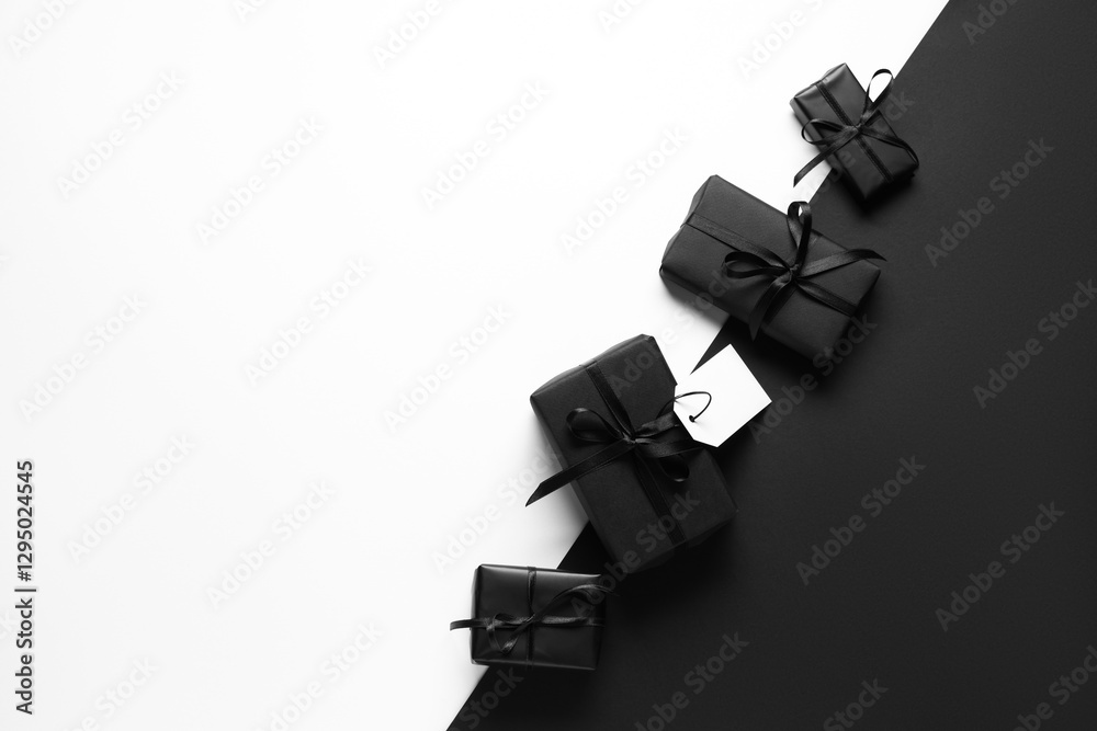 Fototapeta premium Gift boxes with blank paper tag on color background. Black Friday sale