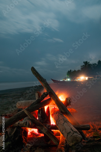 Wallpaper Mural Small campfire with gentle flames beside the sea with stars in the sky Torontodigital.ca