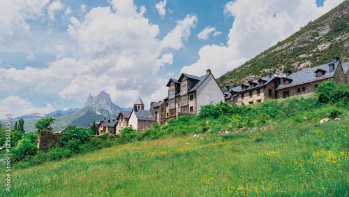 Un pueblo pintoresco entre las montañas un día soleado con cielo azul y nubes. Desde Lanuza, los pirineos, Huesca, Aragón, España.