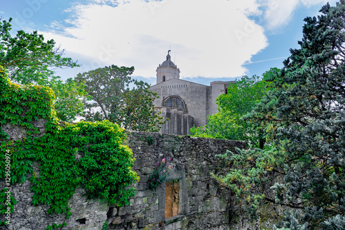 Una ciudad medieval tras su muralla un día soleado con cielo azul y nubes. Desde Girona, Cataluña, España, Europa.