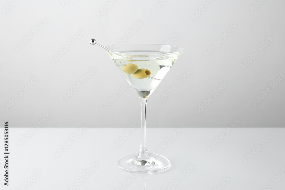 Martini cocktail with olives in glass on light table Martini cocktail with olives in glass on light table