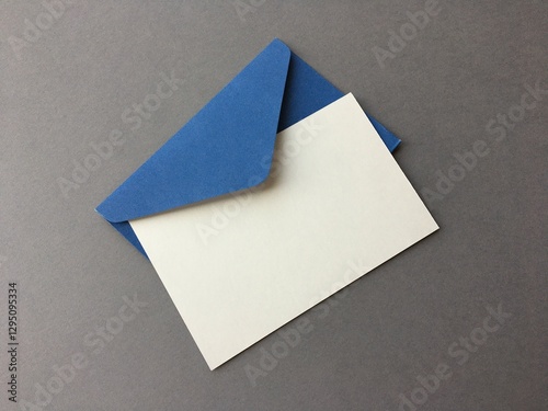 White blank card and blue envelope on gray background