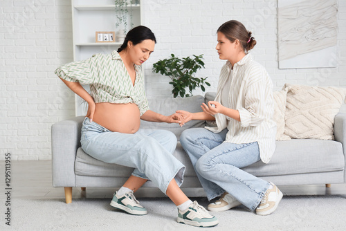 Young doula holding pregnan...