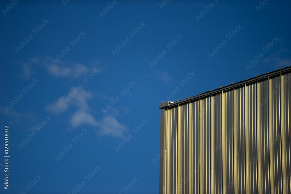 Striking Industrial Building with Bright Blue Sky Background Striking Industrial Building with Bright Blue Sky Background