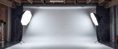 Professional Photography Studio Interior with White Backdrop and Octabox Lighting Equipment Against Brick Wall Background