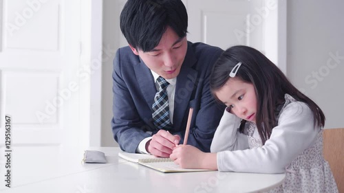 家庭教師の先生と一緒に勉強する小学生の女の子
