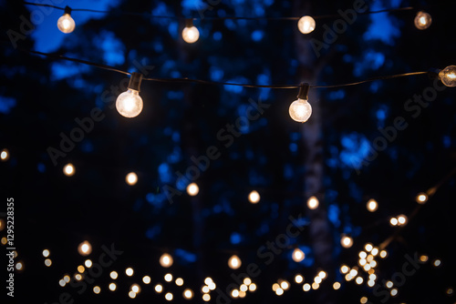 Sphere Light bulb, represent unity and harmony, on electricity wire, decorated by lovely family for holiday or anniversary celebration, illuminate in the outdoor dinner festival party at night