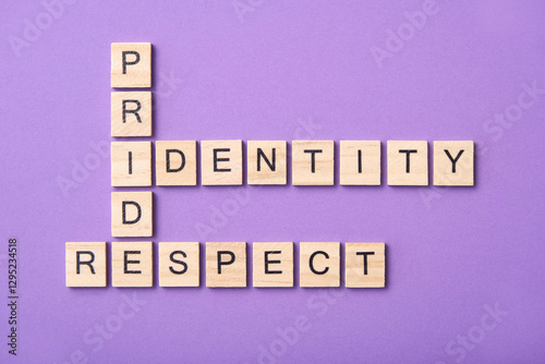 Wooden letters form a crossword puzzle with the words Pride, Identity, Respect. photo