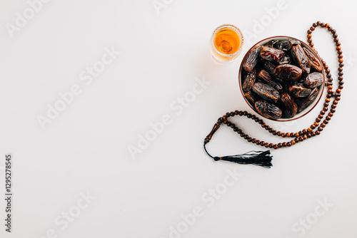 Photography Muslim holiday decor, dates fruit, beads, and tea on a white background