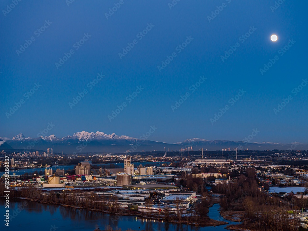 Obraz premium Delta BC Canada - February 11th 2025: Sunset at Deas Island Regional Park waterfront with mountain and moonrise