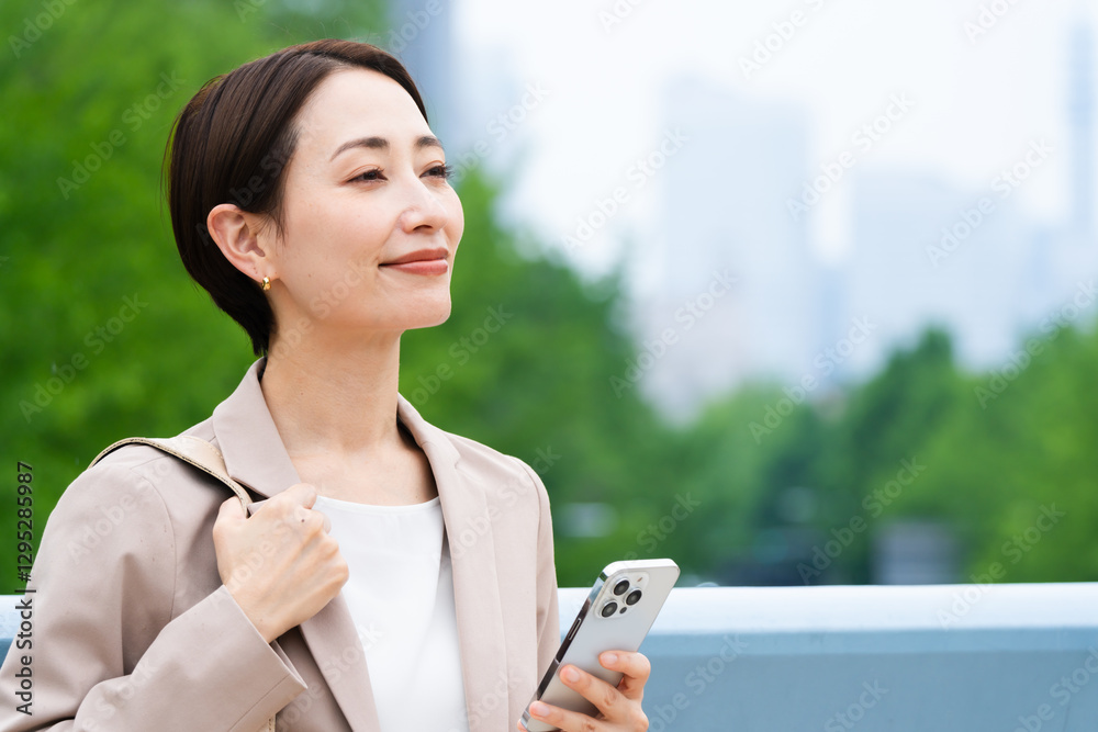 スマートフォンを操作している若い女性 ビジネスイメージ スマートフォンを操作している若い女性 ビジネスイメージ