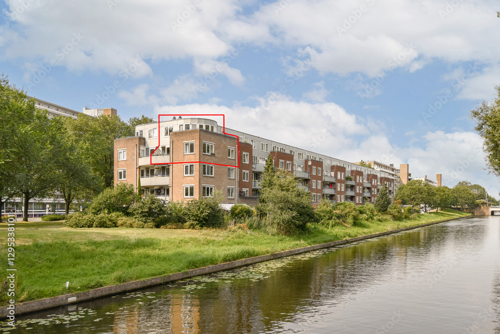 Contemporary residential architecture bordered by greenery and a tranquil water channel creates a serene urban environment. Contemporary residential architecture bordered by greenery and a tranquil water channel creates a serene urban environment.