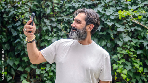 Canvas Print A middle-aged, fair-skinned, bearded, dark-haired man taking a selfie with his c