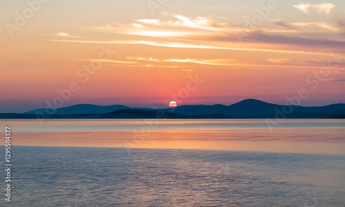 Stunning Sunset Over Calm Water with Mountain Silhouette