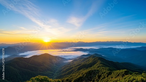 Stunning Sunrise Over Majestic Mountains with Fog and Lush Greenery in Vibrant Sky and Expansive Landscape at Golden Hour