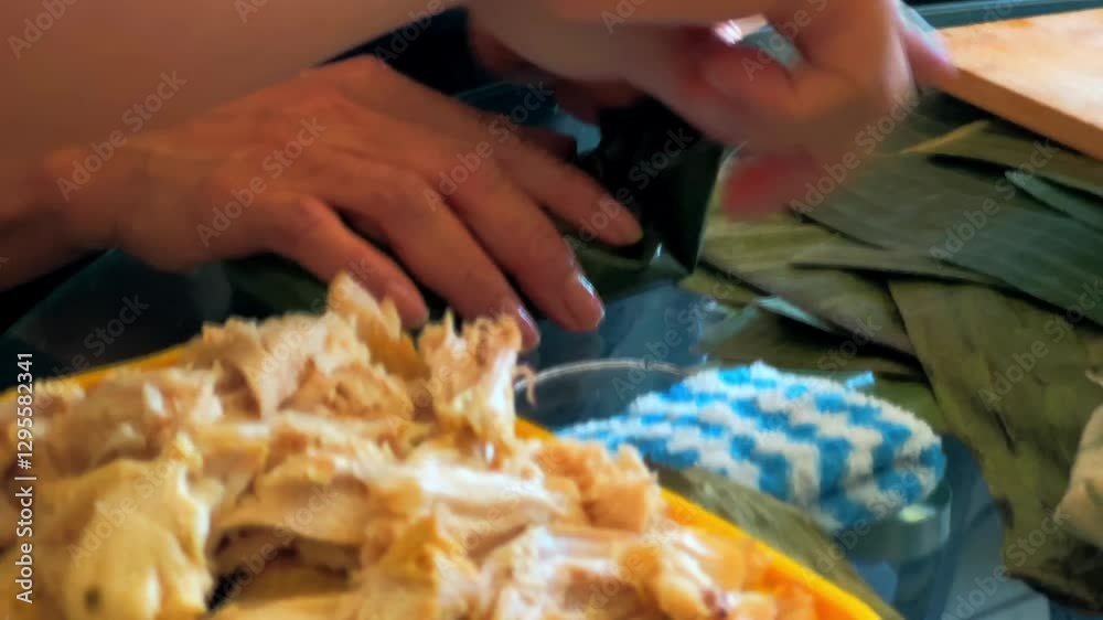 Hands of a old brown woman wrapping a hallaca in a banana leaf, part of the typical Venezuelan Christmas dish, family preparation. Hands of a old brown woman wrapping a hallaca in a banana leaf, part of the typical Venezuelan Christmas dish, family preparation.