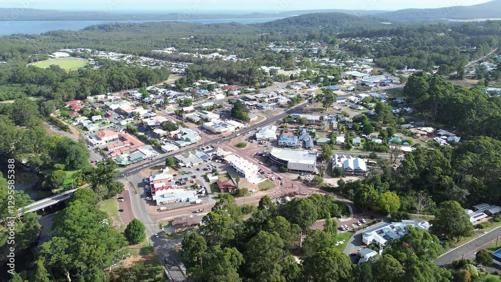 Aerial view of small rural town in Denmark, Western Australia.Looking down on the main road and a bridge. Homes, businesses and rooftops along with moving cars. The Denmark river in view. 4k footage Aerial view of small rural town in Denmark, Western Australia.Looking down on the main road and a bridge. Homes, businesses and rooftops along with moving cars. The Denmark river in view. 4k footage