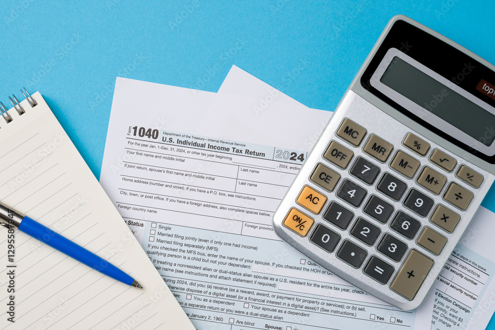 Top view of tax forms, calculator and pen on blue table Top view of tax forms, calculator and pen on blue table
