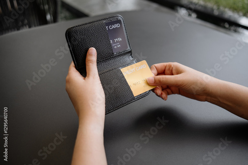 Close-up of woman's hand is taking out a credit card to pay at a cafe or restaurant.