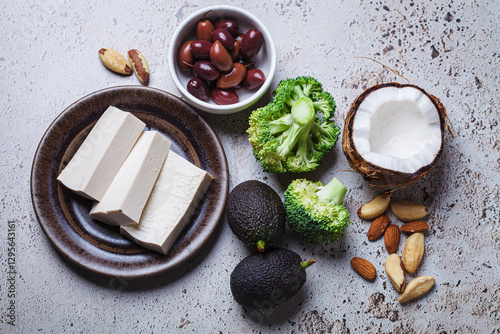 Vegan ingredients for keto diet: tofu, avocado, nuts, broccoli, coconut and olives.