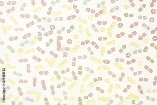 Pastel-colored pills and capsules scattered on a white background.