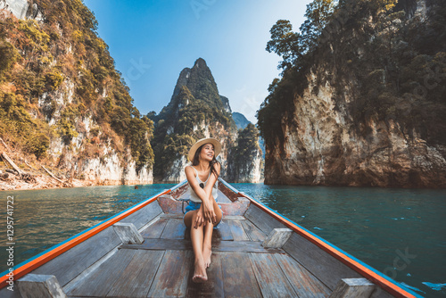 Traveler asian woman relax and travel on Thai longtail boat in Ratchaprapha Dam at Khao Sok National Park Surat Thani Thailand