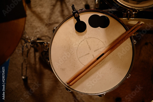 Top view of worn out drumsticks placed on drumhead in recording studio, copy space photo