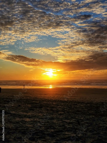 Gorgeous yellow-orange cloudy sunset over the Pacific Ocean in Oregon.