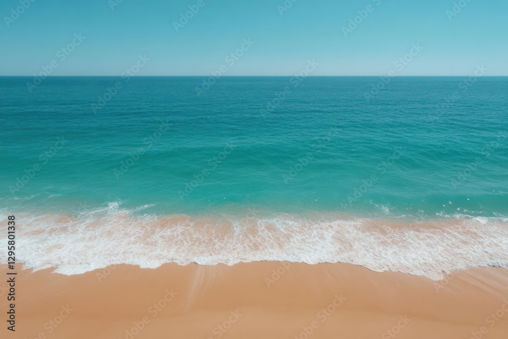 Waves gently crashing on a sandy beach under a clear blue sky during midday Waves gently crashing on a sandy beach under a clear blue sky during midday