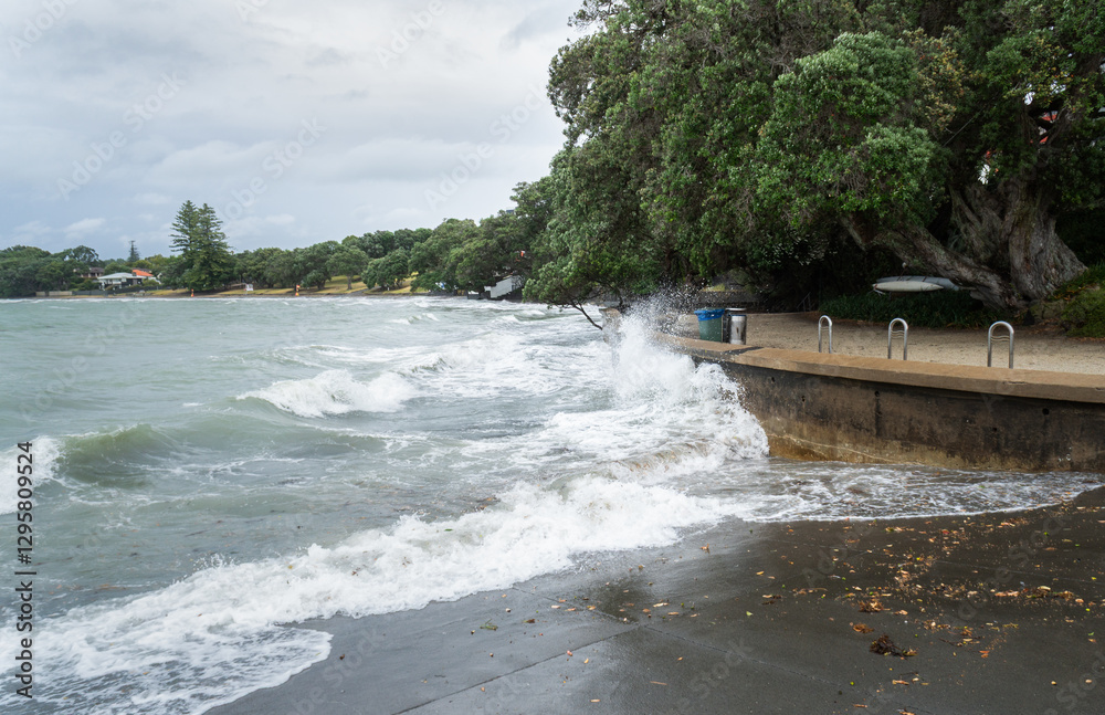 Big ocean waves smashing on the seawall at Takapuna Beach. Auckland.
