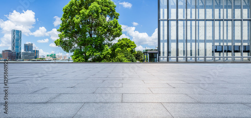 Obraz na płótnie Empty square floor and modern glass wall building with green trees in city park w salonie