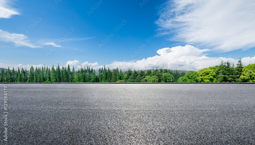 Empty asphalt road with green trees and blue sky on a sunny day