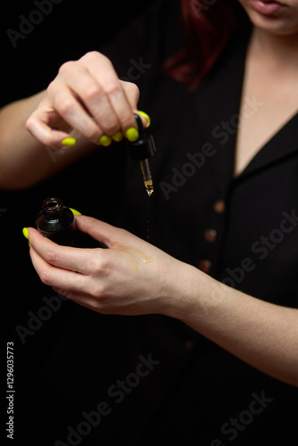 Obraz na płótnie Woman applying skincare oil using dropper, hand treatment, moisturizing beauty care ritual at home, aesthetic lifestyle for healthy skin, skincare concept w salonie