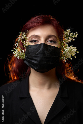 Obraz na płótnie Portrait of Woman with Red Hair Wearing Black Mask Adorned with Delicate Flowers, Capturing Unique Style Concept w salonie