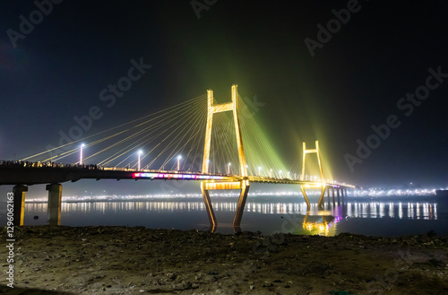 modern architectural bridge glowing over ganges river in night lights