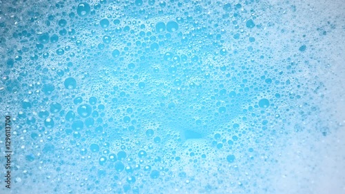 Soap suds in water, bubbles float and burst Abstract white soap foam texture. Concept of cleaning and washing.