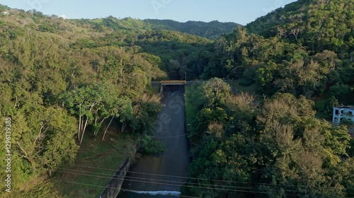 Drone dolly-in over Hatillo Dam, Cotuí, Dominican Republic, surrounded by tropical forest photo