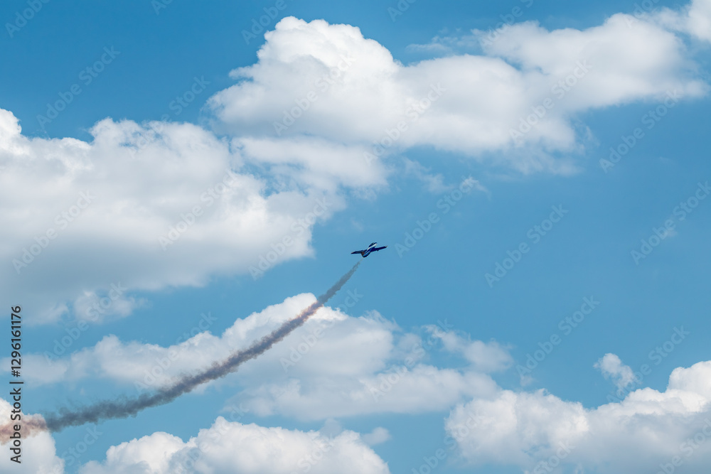 Fototapeta premium Jet Plane with Contrails in Cloudy Sky