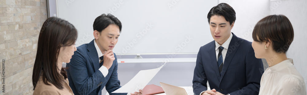 複数の男女のビジネスマンのミーティングの様子 資料を検討したり悩むイメージのバナー 複数の男女のビジネスマンのミーティングの様子 資料を検討したり悩むイメージのバナー