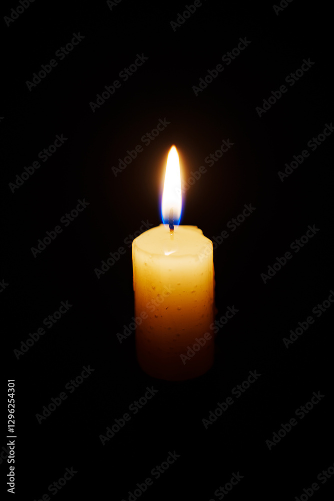 Close-up single candle burning on dark black background, candle fire flame light. Close-up single candle burning on dark black background, candle fire flame light.