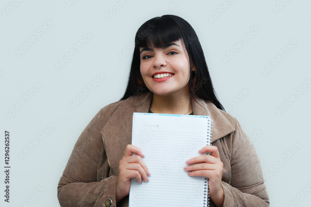Happy young woman holding a notebook. Concept of writing, planning, education, creativity or study. University student excited with her first day at college. Copy space on neutral background. Happy young woman holding a notebook. Concept of writing, planning, education, creativity or study. University student excited with her first day at college. Copy space on neutral background.