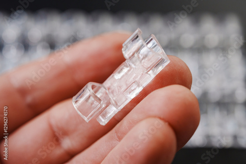 hand and clear plastic wire holders on the black surface. details for a comfortable life and aesthetics.
