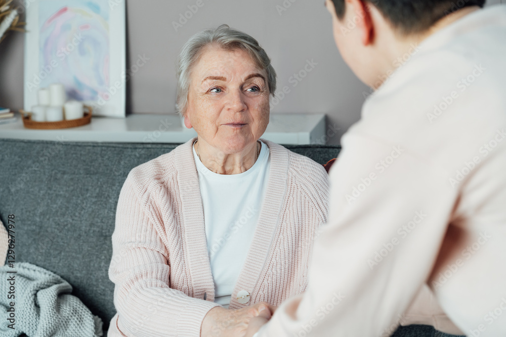 Fototapeta premium No face caregiver warmly holding hands of senior woman. Elderly parents, grandparents care, support. Family enjoying tender moment together at care home, generations relations concept. Age caregiving.