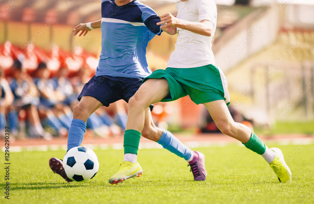 Soccer player kicking a ball on the field. Football duel between two players. Adult soccer players compete in a run. Sports competition on the stadium Soccer player kicking a ball on the field. Football duel between two players. Adult soccer players compete in a run. Sports competition on the stadium