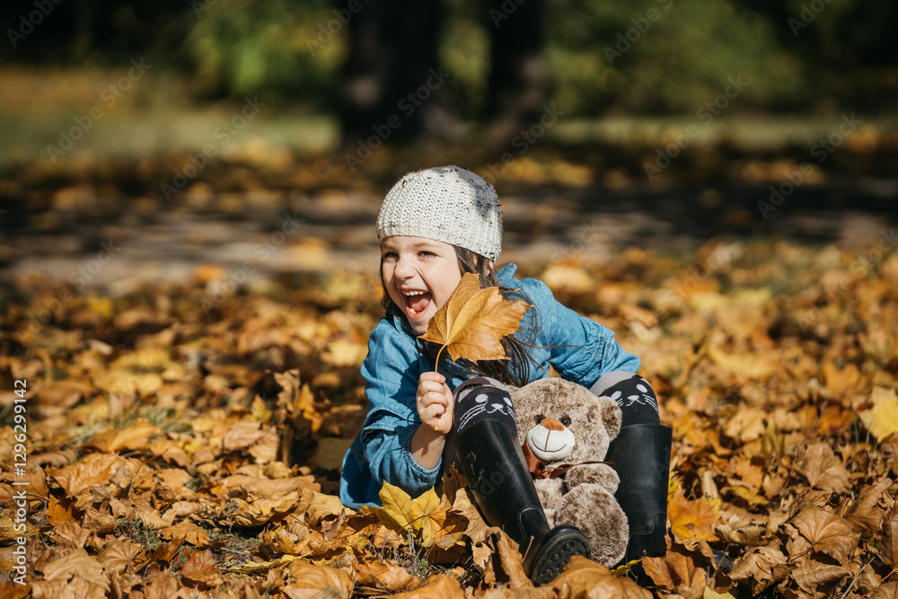 A stylishly dressed little girl plays in an autumn park with a plush toy. The concept of style, comfort, and childhood joy in warm autumn moments. A stylishly dressed little girl plays in an autumn park with a plush toy. The concept of style, comfort, and childhood joy in warm autumn moments.