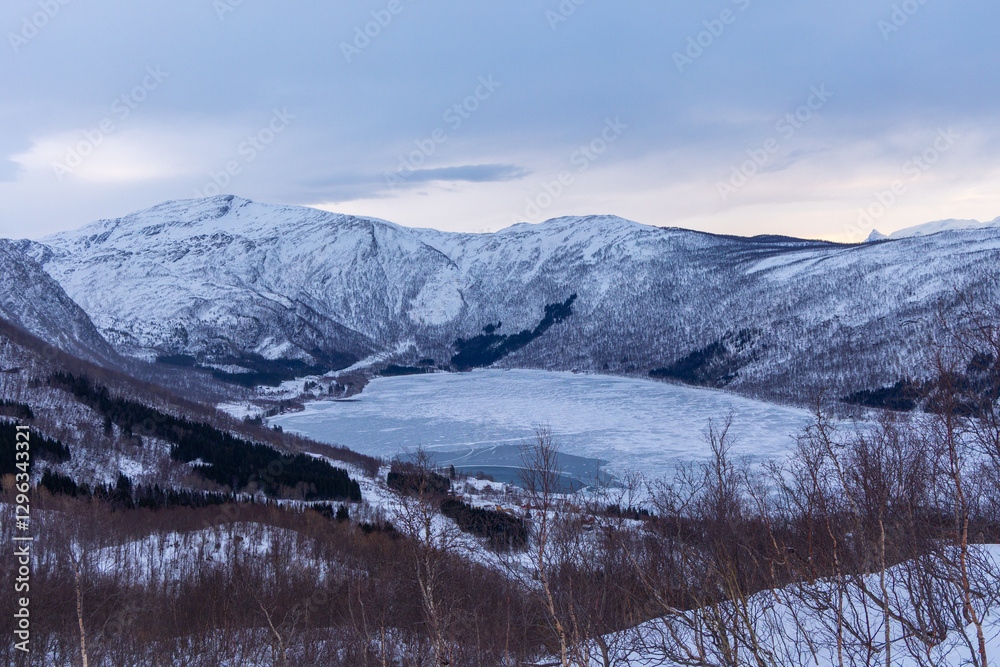 Fototapeta premium A beautiful mountain landscape with snow over the fjords in Norway. Arctic nature in Scandinavia during winter season.