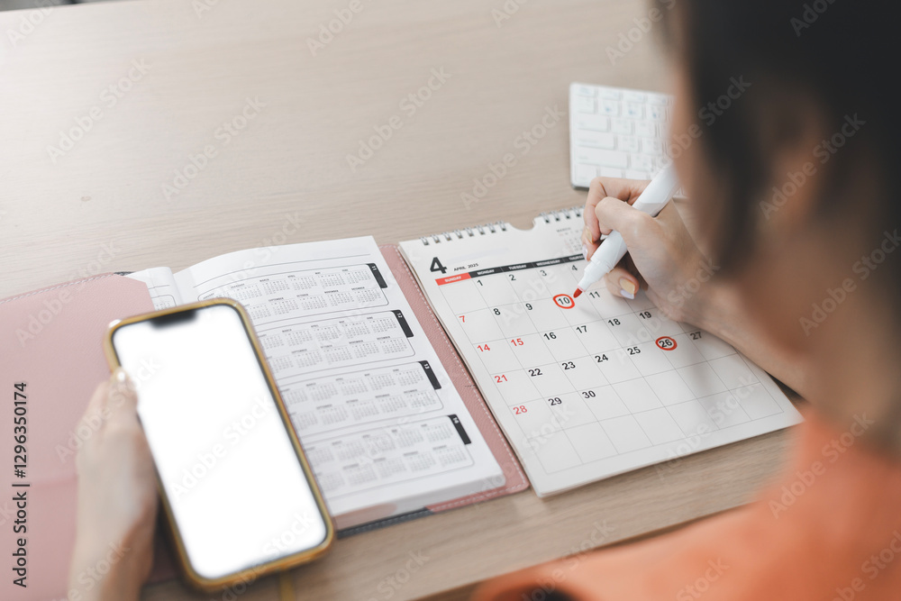 Planning and scheduling meeting calendars, events, time management, reminders and notifications about important events. Woman circling on work calendar. Planning and scheduling meeting calendars, events, time management, reminders and notifications about important events. Woman circling on work calendar.