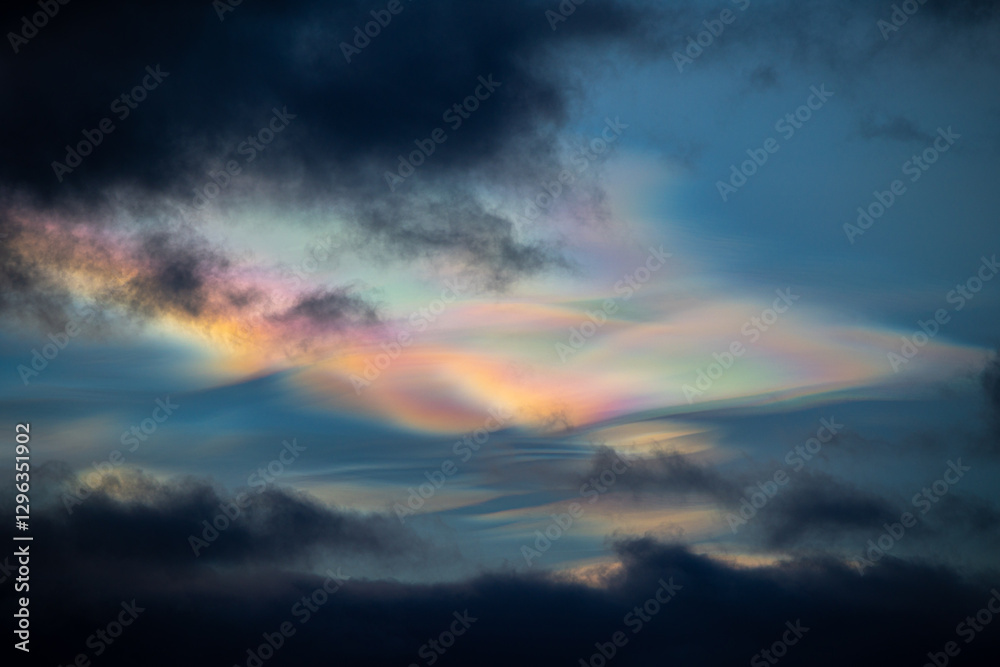 Fototapeta premium A rare polar stratospheric cloud display in the winter skies in Norway. Colorful ice crystals in the sky in sun rays. Arctic nature in Scandinavia during winter season.